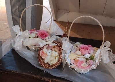 Hochzeit weiße Holzkörbe mir rosa und weißen Rosenblättern und Rosen Floristik