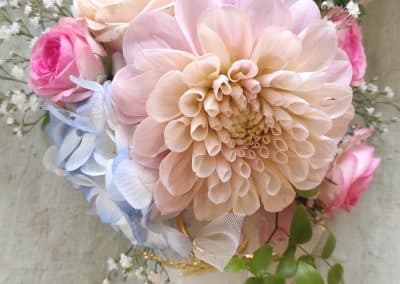 Modernes Braut-Haargesteck mit einer großen Dahlie, Rosen und silberfarbenen Schmuckdraht-Spiralen.